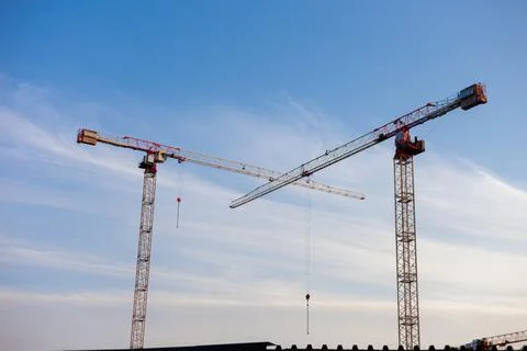 Colored construction cranes on the sky background. Construction of buildings Stock Photos