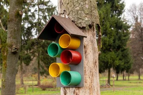 Colored containers installed on a tree resemble a traffic light in a park w.. 库存照片