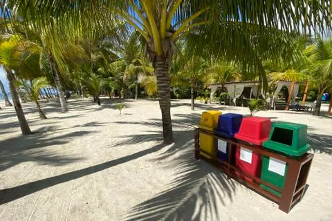 Colored containers for sorting garbage on a white sandy beach,ecology, recycl Stock Photos