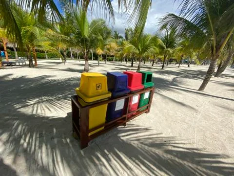 Colored containers for sorting garbage on a white sandy beach.Ecology, recycl Stock Photos