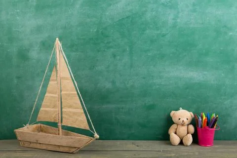 Colored crayons and toy bear on the wooden table - elementary school educatio Foto stock