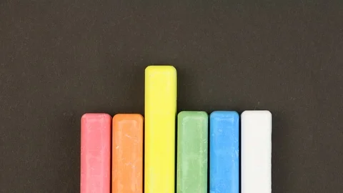 Colored crayons on black lined in row, rises sequentially, education concept Stockbeeldmateriaal 106553156