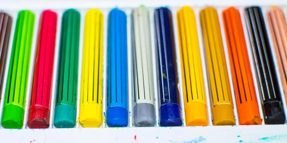 Colored crayons in a box Stock Photos