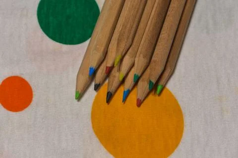 Colored crayons lined up on a colored plane Stock Photos