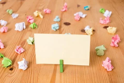 Colored crumpled papers around an empty rectangle square shaped reminder note in Stock Photos