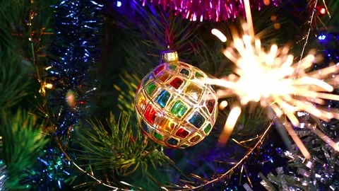 Colored crystal boll on the Christmas tree and sparkler Stock Footage 167239062