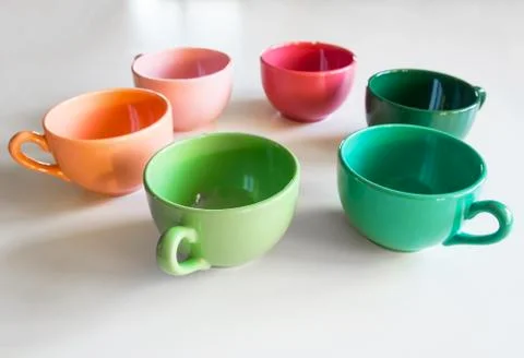 Colored cups on the table background Stock Photos