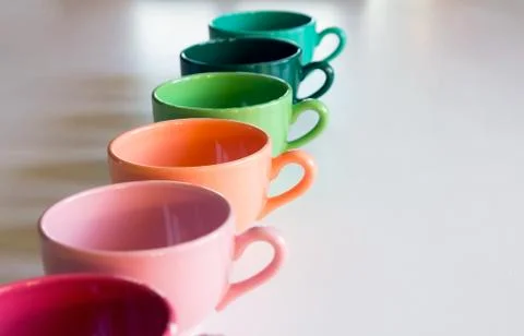 Colored cups on the table background Stock Photos