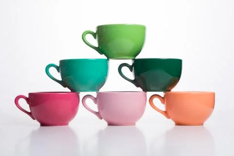 Colored cups on the table background Stock Photos
