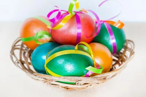Colored decorated Easter eggs in basket Stock Photos