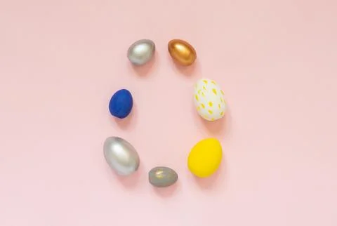 Colored decorated eggs folded in the shape of an egg on a pastel pink backg.. Stock Photos