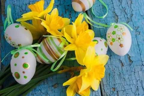 Colored decorative Easter eggs and a bouquet of yellow narcissus 库存照片