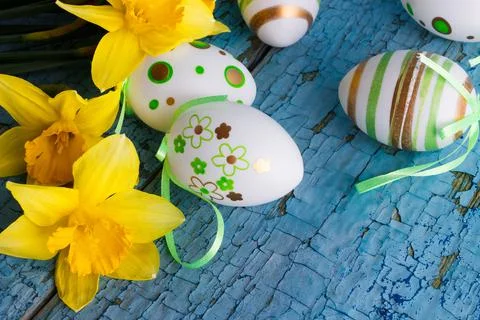 Colored decorative Easter eggs and a bouquet of yellow narcissus Stock Photos