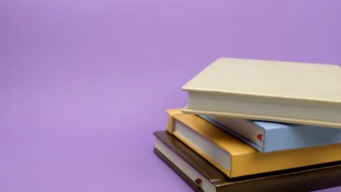 Colored diaries lying on purple background. Видео 127694884