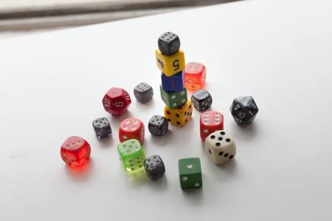 Colored dice stacked and creaticely placed Stock Photos