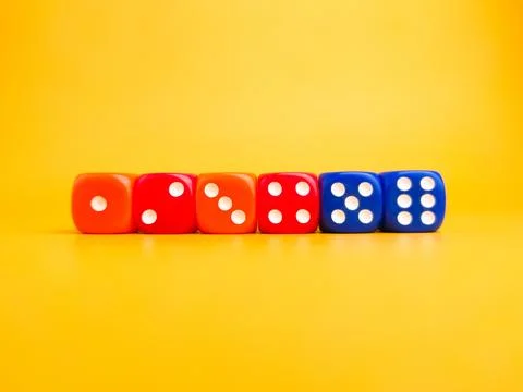 Colored dice on a yellow background. Game play concept. Stock Photos