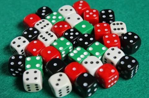 Colored dices on a green mat Stock Photos