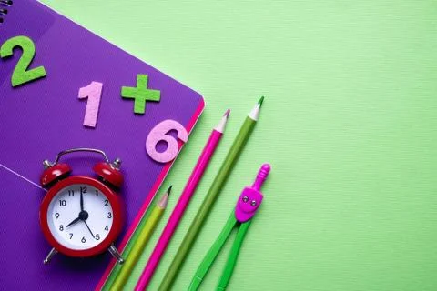 Colored different school supplies on light green paper background. Stock Photos