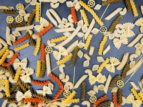 Colored different types of Italian pasta on a dark background. food texture.  Stock Photos