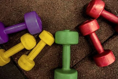 Colored dumbbells on a black background Stock Photos