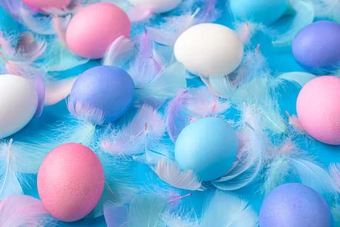 Colored Easter eggs and feathers on a blue background close-up. Foto stock