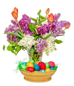 Colored easter eggs and a transparent vase with the flowers: violet and white Stock-Fotos