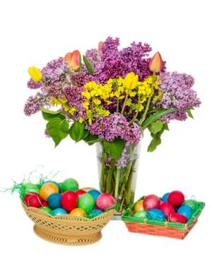 Colored easter eggs and a transparent vase with the flowers: violet and white Stock Fotos