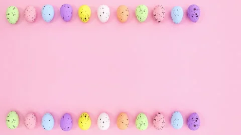 Colored Easter eggs appear on top and bottom of pink theme. Stop motion Stock Footage 148781280