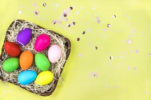 Colored Easter eggs in the basket. Flatlay. Stock Photos