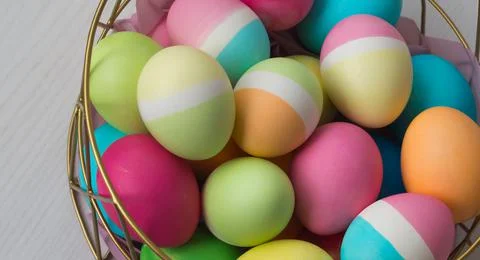 Colored Easter eggs in a basket on the table 写真素材