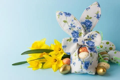 Colored Easter eggs in decorative basket and a bouquet of yellow narcissus Stock Photos