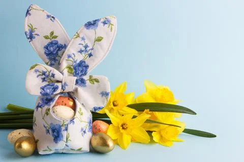 Colored Easter eggs in decorative basket and a bouquet of yellow narcissus Stock Photos