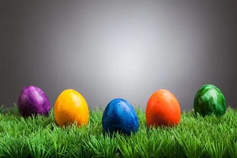 Colored easter eggs in grass, gray background Stock Photos