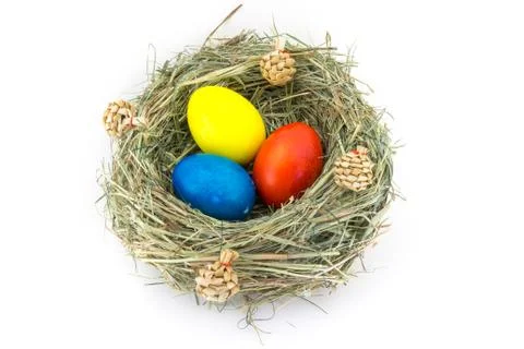 Colored easter eggs in grass nest with bumps Stock Photos