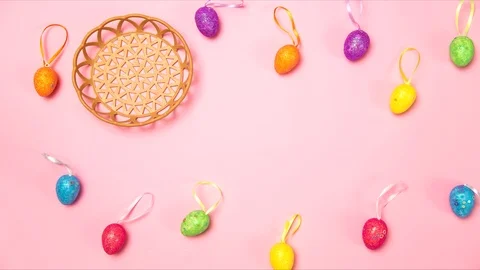 Colored easter eggs jumping from a basket on a pink background Stock Footage 124042028