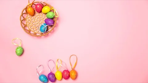 Colored easter eggs jumping to the basket on a pink background Stock Footage 125984987