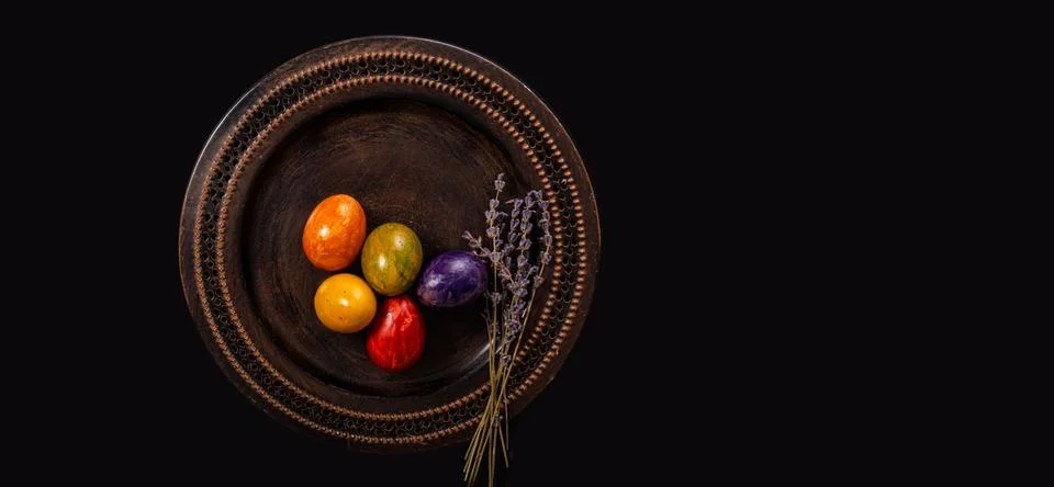 Colored easter Eggs in a plate with black background and copy space. With gra Foto stock