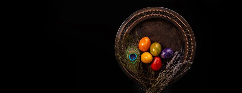 Colored easter Eggs in a plate with black background and copy space. With gra Stock Photos