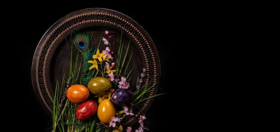 Colored easter Eggs in a plate with black background and copy space. With gra Stock Photos