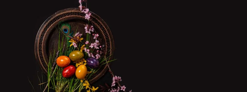 Colored easter Eggs in a plate with black background and copy space. With gra Stock Photos