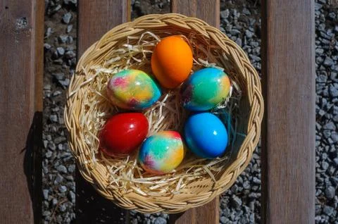 Colored Easter eggs in a wicker basket Stock Photos