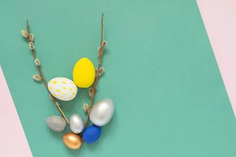 Colored easter eggs with willow branches on color pink and green background. Stock Photos