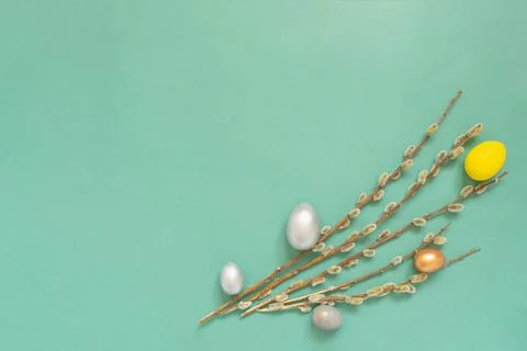 Colored easter eggs with willow branches on color green background. Easter ca Stock Photos