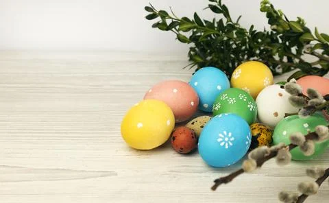 Colored Easter eggs with willow twig and green leaves isolated on white 스톡 사진