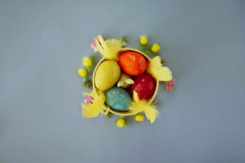Colored easter eggs in a yellow bucket on a blue background Stock Photos