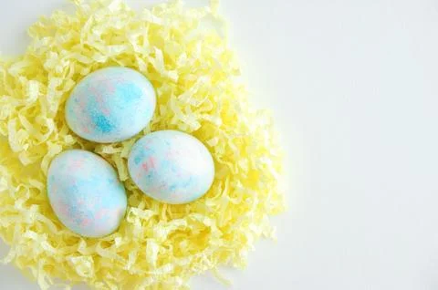Colored Easter eggs in yellow paper shavings. On a white background . Foto stock