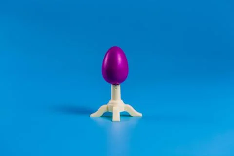 .Colored easter plastic egg on a stand in the form of a rocket Stock Photos