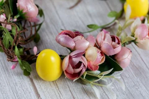 Colored Easter wreath and plastic eggs on white wooden background Foto stock