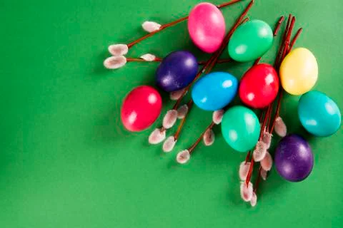 Colored eggs and willow branches on a green background Stock Photos