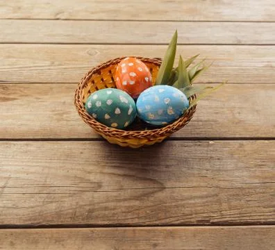 Colored eggs in a basket Stock Photos